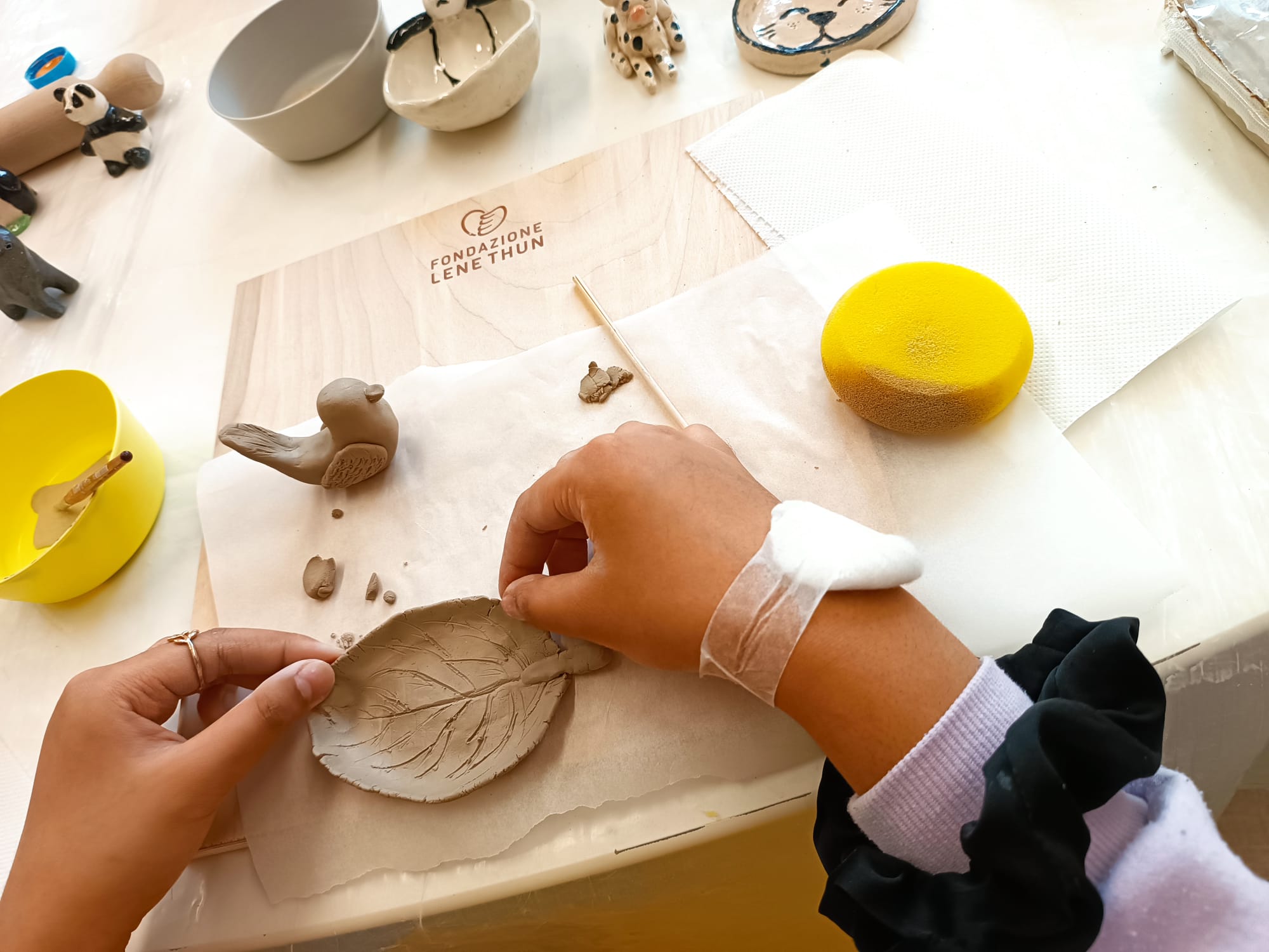 Lavorare l’argilla con i bambini permette di stabilire delle connessioni profonde, sia a livello sensoriale che emotivo. Attraverso la manipolazione dell’argilla, infatti, si entra in contatto con la materia, risvegliando sensazioni tattili tipiche della prima infanzia, gratificanti e piacevoli. Non solo. Vedere realizzarsi dal nulla la forma che fino a quel momento viveva solo nella mente, regala una soddisfazione importante a chi l’ha creata, infondendo un senso di sicurezza e coraggio. Pensate quanto tutto questo può essere benefico per i piccoli pazienti oncologici che devono affrontare un percorso di cura. Per questo, con l’arrivo di settembre, mese dedicato alla sensibilizzazione del tema dell’oncologia pediatrica, vogliamo raccontarti perché lavorare l’argilla con i bambini oncologici è così importante. Lavorare l’argilla con i bambini delle oncologie pediatriche per donare sorrisi I benefici derivati dalla modellazione dell’argilla per i bambini e ragazzi in ospedale sono tanti, ma quello che preferiamo in assoluto è il sorriso. Capita di vederne spesso durante i laboratori di ceramico-terapia: tanti bellissimi sorrisi che aleggiano nell’aria e rendono più gradevole la permanenza in ospedale. Ma l’aspetto più sorprendente della ceramico-terapia è senza dubbio l’influenza positiva sulla ricezione delle terapie farmacologiche: ogni laboratorio di manipolazione dell’argilla dona infatti ai bimbi svariati benefici a livello mentale e fisiologico, permettendo loro di affrontare con maggiore serenità le cure e ridurre gli effetti collaterali.